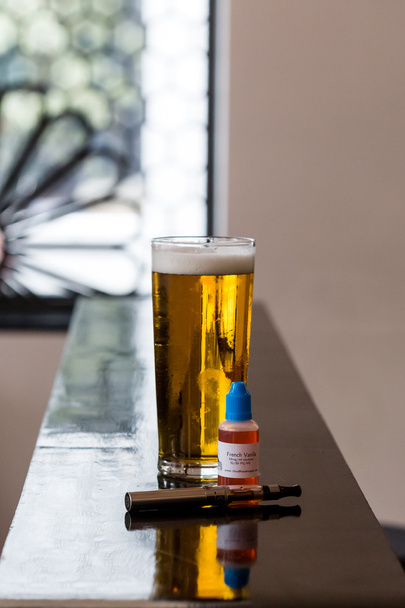 pivo, e šťávy a elektronická cigareta na stole - Fotografie, Obrázek