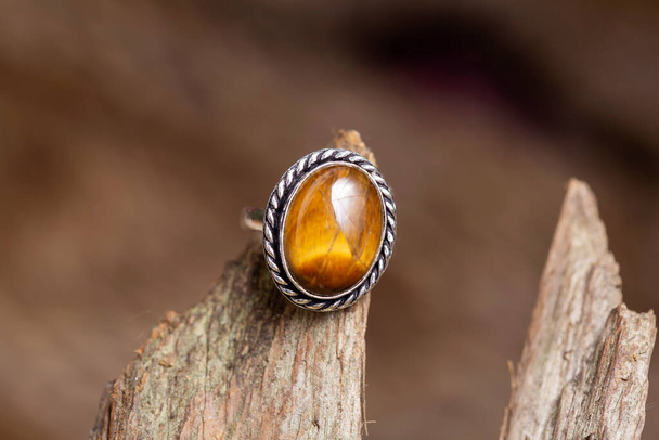 Brass metal tiger eye mineral stone ring on natural background - Photo, Image