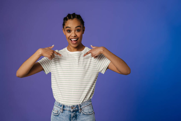 Excited black woman in t-shirt smiling and pointing fingers at herself isolated over blue background - Fotografie, Obrázek
