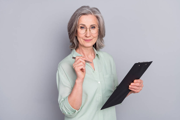 Photo of mature smart intelligent good mood businesswoman hold check list isolated on grey color background - Φωτογραφία, εικόνα
