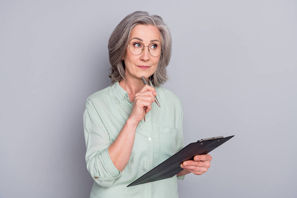 Retrato de atractiva mujer de pelo gris de mente creando escritura lista de tareas aisladas sobre fondo de color pastel gris - Foto, imagen