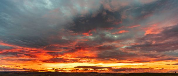 Tiefrot bewölkt Sonnenuntergang mit Bergkette - Foto, Bild