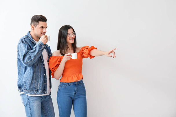 Young couple drinking coffee on light background - Foto, immagini