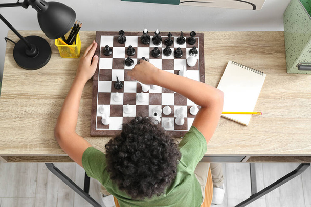 Cute African-American boy playing chess at home, top view - Photo, Image