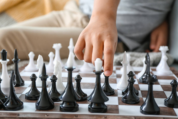 Симпатичный афроамериканец играет в шахматы дома, крупным планом - Фото, изображение