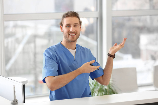 Male receptionist showing something in clinic - Photo, Image