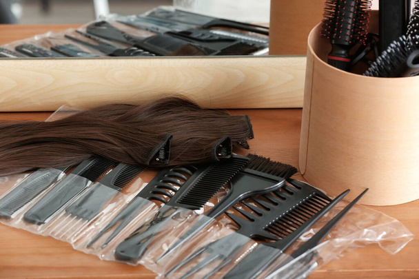 Barber set with strands of hair and brushes on table in beauty salon - Photo, Image
