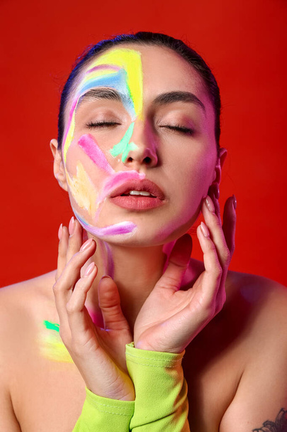 Hermosa mujer joven con pintura en su cuerpo contra el fondo de color - Foto, imagen