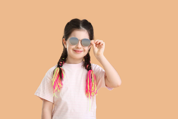 Cute little girl wearing sunglasses on color background - Photo, Image
