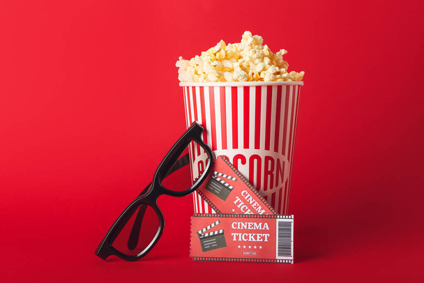 Κουβάς με νόστιμο ποπ κορν, 3D γυαλιά και εισιτήρια κινηματογράφου στο φόντο χρώμα - Φωτογραφία, εικόνα