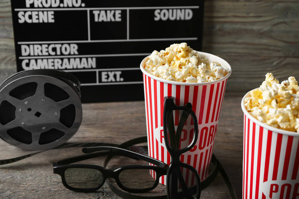 Composition with popcorn and 3D glasses on dark wooden background - Фото, изображение