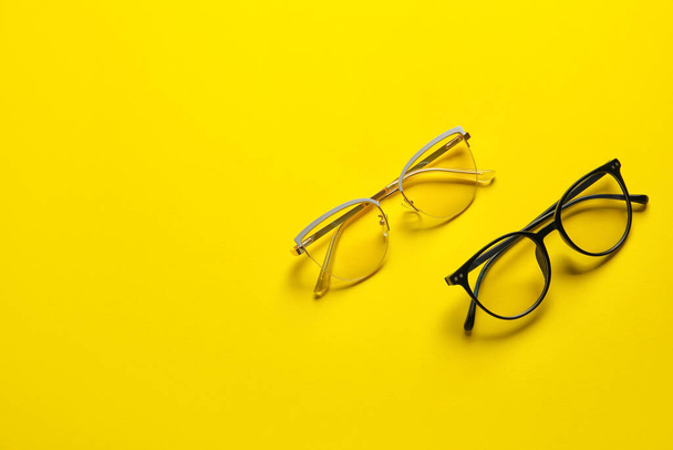 Different stylish eyeglasses on color background - Foto, afbeelding