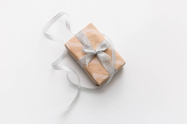 Подарункова коробка зі срібною стрічкою на білому тлі
 - Фото, зображення