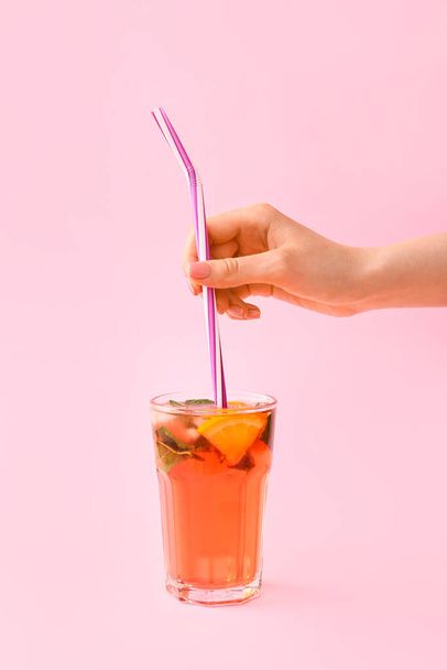Female hand and glass of tasty ice tea on color background - Photo, Image