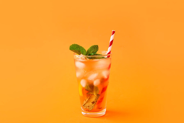 Egy pohár ízletes jeges tea citrommal a színes háttér - Fotó, kép