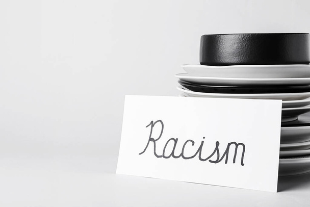 Papír darab szó RACISM és lemezek fehér háttér - Fotó, kép