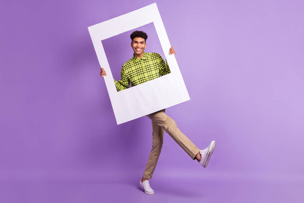 Full length body size of young man keeping photo frame cadre smiling on photo isolated on pastel violet color background - Фото, зображення