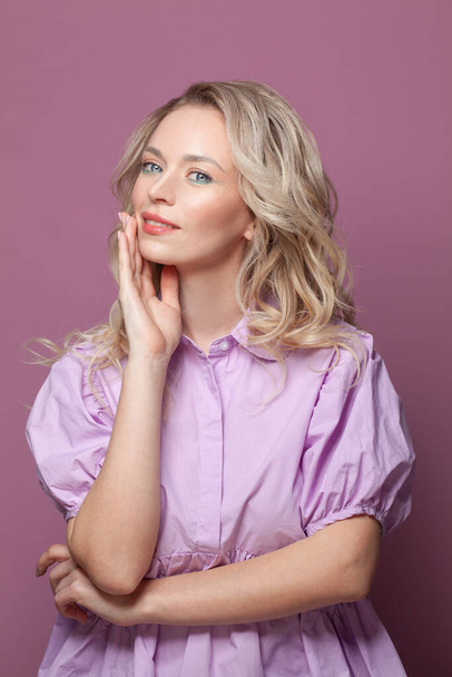 Roztomilá optimistická žena s blond vlasy v růžové blůze na jasně růžovém pozadí, studiový portrét - Fotografie, Obrázek