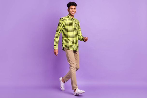 Full length body size view of attractive cheerful guy wearing checked shirt going step isolated over violet purple color background - Fotó, kép