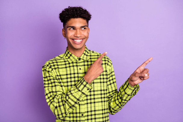 Photo of happy dark skin handsome young man point look empty space isolated on purple color background - Foto, imagen