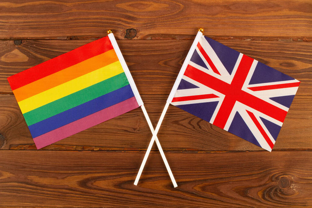 Bandera arco iris LGBT y bandera de Australia sobre tabla de madera marrón fondo. Mes del Orgullo LGBT. LGBTQ. LGBTQIA. De cerca. Vista superior - Foto, imagen