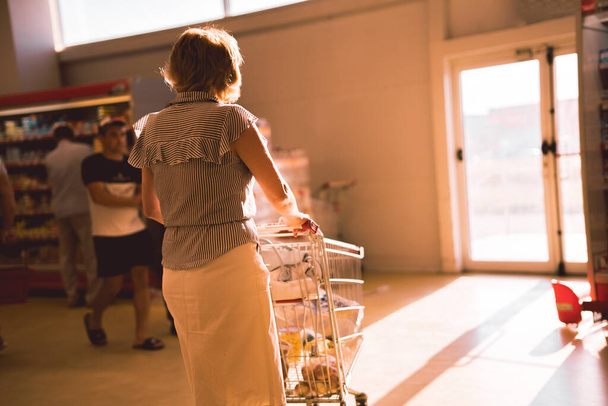 Frau mit Einkaufswagen im Lebensmittelladen - Foto, Bild