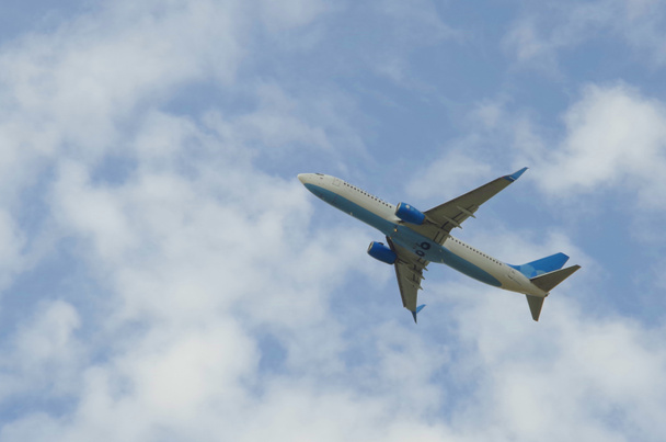 Samolot lata po niebie z chmurami - Zdjęcie, obraz
