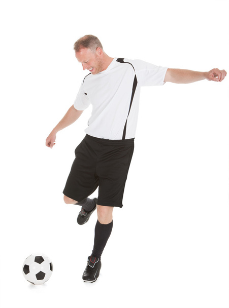Jugador de fútbol pateando fútbol
 - Foto, imagen