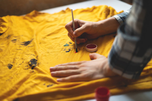 drawing with a brush on a t-shirt, personal unique clothes design concepts - Foto, afbeelding