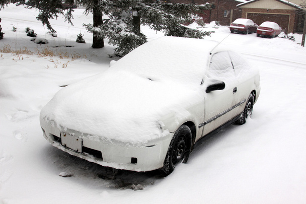 tamamen karla kaplı bir driveway içinde oturan bir araba. - Fotoğraf, Görsel