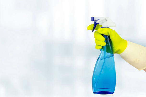 Концепция весенней уборки. спрей для рук. женщина держит бутылку моющего средства на белом фоне. общая или регулярная очистка - Фото, изображение