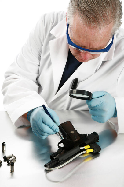 Forensic Analysis. Police crime detective documents evidence collected from crime scene. Forensics investigator. Forensics investigator collecting evidence from a gun and bullets used in a crime. Hematological test kit. crime lab. Crime Scene. - Photo, Image