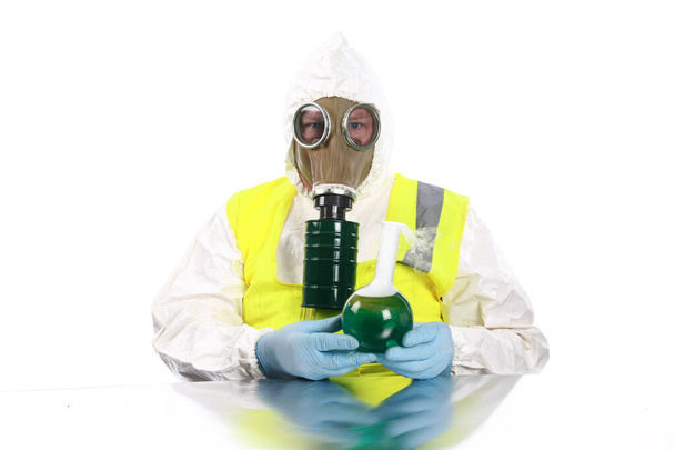 Anarchist. Anarchist wearing a hazmat suit, gloves and gas mask mixes dangerous chemicals together in a lab in preparation of evil plans. An Evil Chemist creates Coronavirus in a lab. Covid-19 is created by evil scientist.  - Photo, Image
