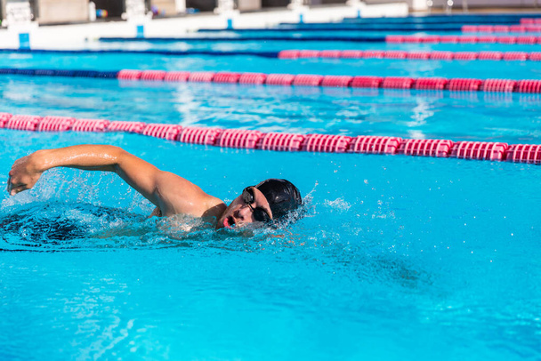 水泳プールでの水泳マンスポーツトレーニング。クロールを行うプロの男性選手フリーストロークテクニック - 写真・画像