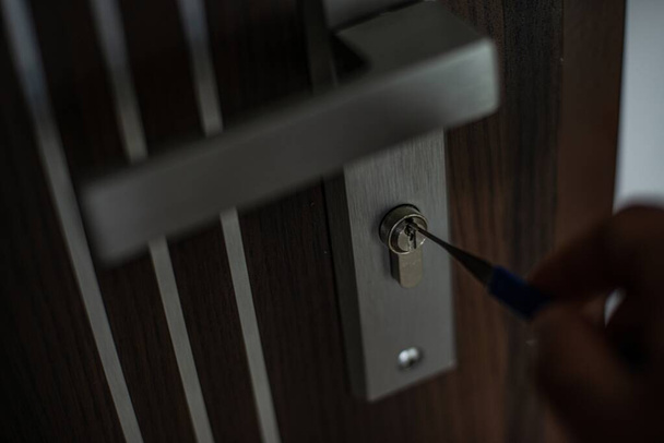 Close-up of a persons hand opening door with lockpicke - Photo, Image