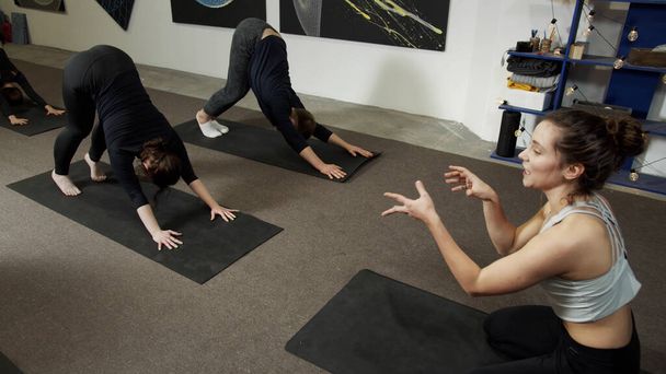Cvičení jógy v malé místnosti s obrazy na bílé stěně - Fotografie, Obrázek