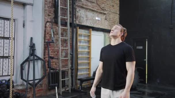 Een sterke sporter springt en hangt aan gymnastiekringen - Video