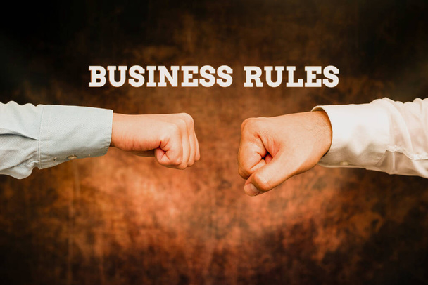 Hand writing sign Business Rules. Conceptual photo the principles which determine the corporation s is activities Two Professional Well-Dressed Corporate Businessmen Handshake Indoors - Foto, Bild