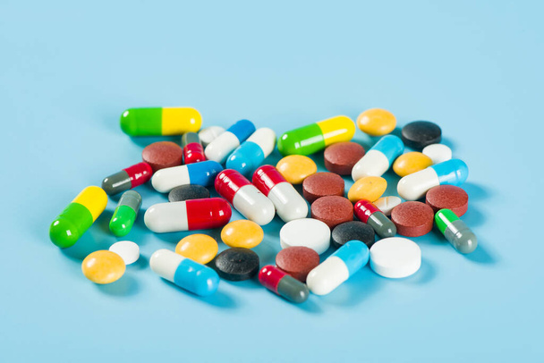 Verschiedene pharmazeutische Medizin-Pillen, Tabletten und Kapseln auf blauem Hintergrund - Foto, Bild