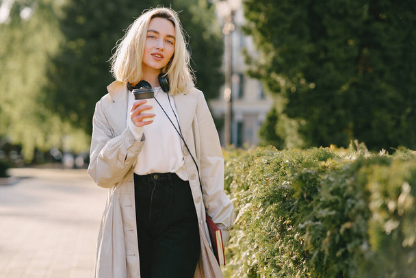 Blonde walks in summer city with cup of coffee - Zdjęcie, obraz