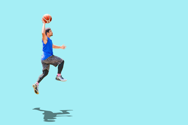 Asian basketball player jumping dunk to score on colored background - Photo, Image