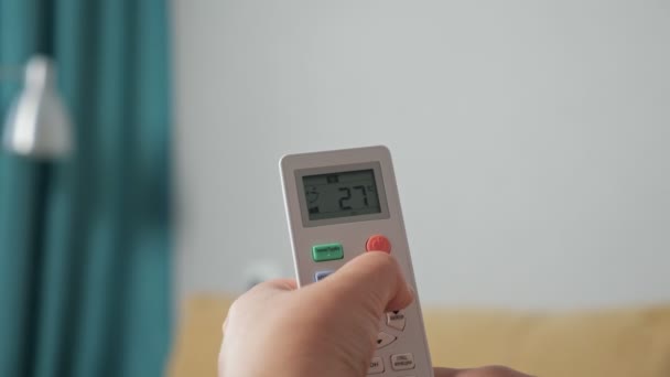 Close-up de uma mão que regula um ar condicionado com um controle remoto - Filmagem, Vídeo