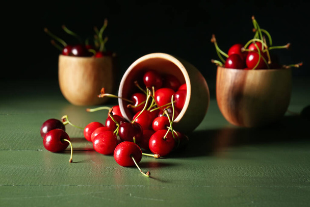 Tigelas com cereja madura saborosa no fundo escuro - Foto, Imagem