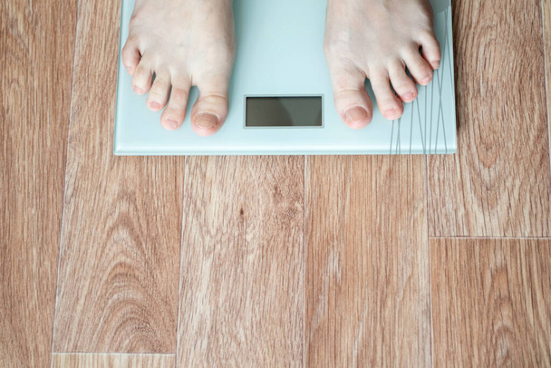 Feet stepping on floor weigh scales - Photo, Image