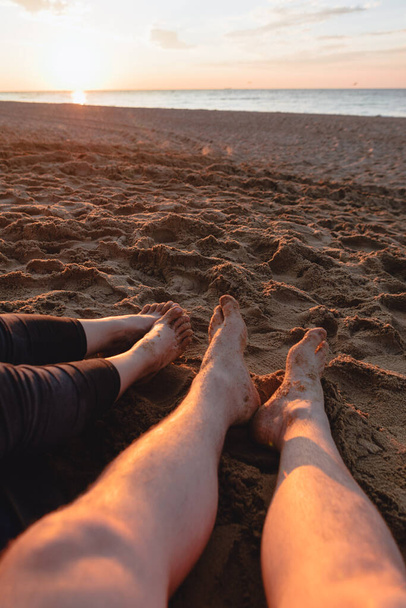 pár ül homokos tengerparton nézi naplemente. másolás helye. - Fotó, kép