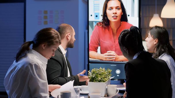 Diverse multi-ethnic businesspeople discussing with remote manager during online videocall - 写真・画像