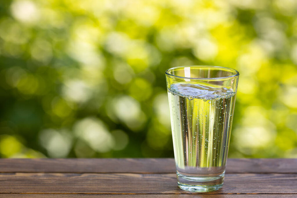 glass of clean mineral water on table outdoors - Photo, Image