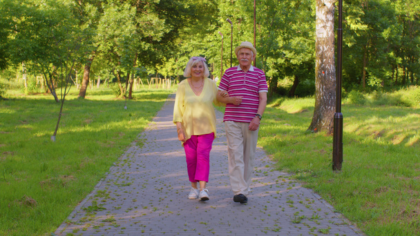 Senior stylowe emeryci para babcia dziadek spacery, ciesząc się razem w parku - Zdjęcie, obraz