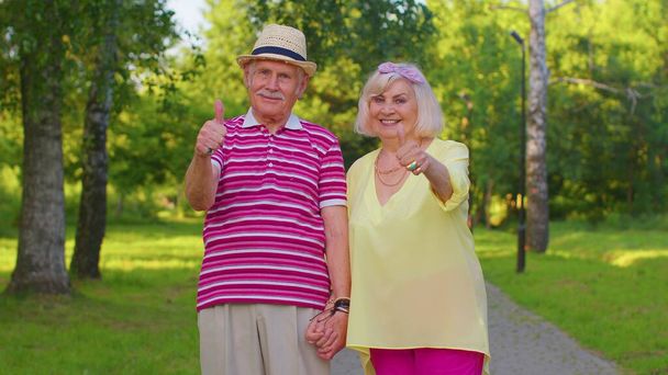 Senior stylish couple grandmother grandfather looking approvingly showing thumb up like sign gesture - Photo, Image
