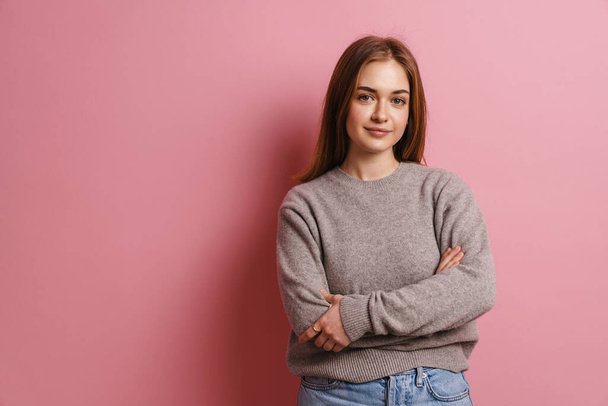 Young ginger pleased woman posing with arms crossed isolated over pink background - Fotoğraf, Görsel